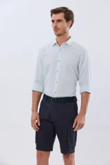 Bermuda cargo color azul marino, de gabardina con bolsillos laterales con solapa en las piernas y presillas para cinturón. Incluye cinturón de lona trenzada oscura con detalles en cuero sintético y hebilla metálica.