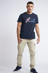 Pantalón cargo color beige de corte slim, con cintura elástica y cordón de ajuste. Presenta bolsillos laterales tipo cargo y puños elásticos en los tobillos.