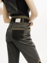 Pantalón de jean tiro alto con corte ochentoso y terminación oxford. Presenta paneles laterales en contraste y costuras decorativas en color amarillo a lo largo de las piernas.