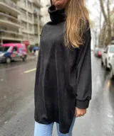 Polerón negro de terciopelo con cuello alto y mangas largas.