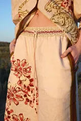 Pantalón de lino color nude con estampado de flores rojas y tigre blanco.