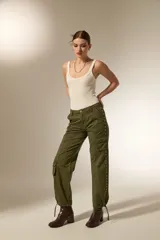 Pantalon cargo de algodón color gris oscuro, de tiro alto y corte recto. Presenta bolsillos laterales tipo cargo y una hilera de ojales metálicos decorativos a lo largo de la pierna derecha.