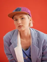Gorro con visera colorblock, con paneles en color marrón, violeta y azul.
