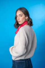 Sweater color beige de lana mohair y acrílico, con cuello redondo y mangas largas.