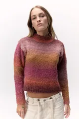 Sweater tejido de punto en hilado bouclé con degradé de colores naranja y rosa. De calce al cuerpo, cuello alto y suave textura.