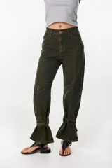 Jean baggy de tiro alto y pierna recta y ancha, color verde militar con efecto acid wash. Presenta bolsillos traseros grandes con costuras destacadas y un monograma bordado en el bolsillo izquierdo.