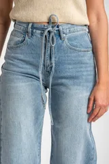 Jean wide leg de tiro medio en color celeste claro, con lavado clásico y cordón ajustable en la cintura.