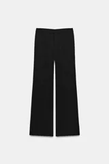 Pantalón negro de tiro bajo, corte recto con trabillas en la cintura y raya planchada al frente. Cuenta con bolsillos laterales y falsos bolsillos de vivo en la espalda. Cierre frontal con cremallera, botón interior y ganchos metálicos.