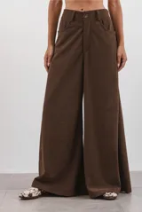 Pantalón de corte ancho confeccionado en corderoy color chocolate, con cintura alta, pasacintos y cierre frontal con botón.