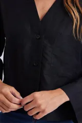 Camisa negra de lino con cuello en V y cierre frontal con botones.
