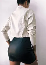 Minifalda negra de cuero sintético, corte ajustado y cintura alta.