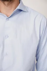 Camisa celeste de corte ajustado, fabricada con tejido suave de India, con botones coordinados.