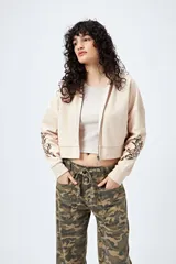 Canguro cropped negro con cierre frontal y estampa abstracta en contraste en las mangas.