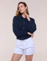Camperita bomber de lyocell con textura suave, color azul marino, cuello camisero, cierre frontal con botones a presión, bolsillos laterales con solapa, mangas largas con puños elásticos y pretina fruncida en el ruedo.