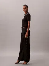 Pantalón de pierna ancha color negro, confeccionado en sarga de algodón, con cintura elástica y diseño moderno.