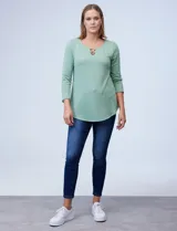 Blusa verde agua en tejido texturado, con cuello redondo y escote en V con aplique de aros metálicos.