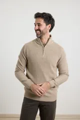 Sweater verde de punto inglés con cuello alto y cierre metálico frontal. Tiene mangas largas y terminaciones en punto canalé.