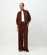 Pantalón wide leg de cintura alta en color marrón, confeccionado en modal con viscosa y elastano. Cuenta con cintura posterior elástica, cinta con hebilla para ajustar, bolsillos delanteros amplios tipo cargo y piernas rectas.