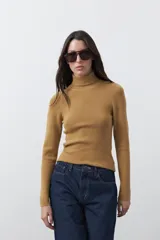 Polera de manga larga y cuello alto, confeccionada en tejido de punto fino, con un ajuste ceñido al cuerpo.