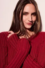 Sweater de punto acanalado en color negro con sutil acabado brillante. Presenta un diseño ajustado al cuerpo, cuello redondo y mangas largas.