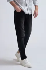 Pantalón de jean slim fit color gris oscuro, con desgaste en la parte superior de los muslos y ruedo con dobladillo.