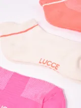 Pack de tres pares de soquetes tobilleros en colores rosa, blanco y naranja, con detalle de una línea horizontal en el borde superior.