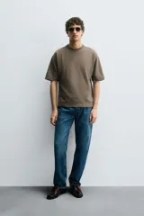 Camiseta de corte relajado confeccionada en algodón compacto, con cuello redondo y mangas cortas sin costura de sisa.