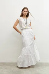Blusa blanca con bordado calado, de corte recto y mangas cortas.
