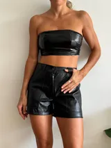 Short negro de cuero sintético con textura crocco, tiro alto, corte ajustado, bolsillos laterales y cierre frontal con botón.