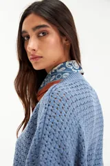 Sweater de tejido de punto con textura tipo esterilla, color azul piedra, con escote en V y mangas largas de corte holgado.