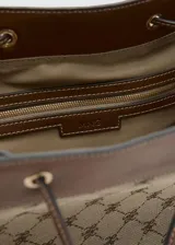 Bolso tipo bucket de poliéster y poliuretano, con diseño estampado geométrico en tonos marrón y beige, detalles en cuero sintético marrón, cierre de cordón ajustable y asa de hombro.