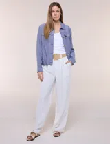 Camperita de lino liviana, marca Dash, con estampado botánico de hojas en tonos azules, verdes y tostados sobre base blanca. Presenta cierre frontal con botones, cuello clásico y bolsillos aplicados en el pecho.