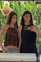 Top de cuello halter con lazada, confeccionado en tejido efecto ante. Presenta un diseño cubierto de flecos con tachas aplicadas en toda la superficie.