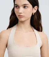 Blusa frente única de microfibra color beige, con escote cuadrado y breteles que se ajustan al cuello. Diseño sin mangas y espalda descubierta.