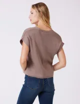 Cardigan tejido en hilado fino color marrón, con escote en V, mangas cortas y abertura central con botones metálicos dorados.