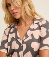 Conjunto de pijama americano corto confeccionado en viscosa certificada, compuesto por una blusa de manga corta con cuello solapa y abotonado delantero, y un short con cintura elástica y lazo. Estampado de corazones.