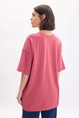 Remera de manga corta oversize color rojo, con cuello redondo y estampa frontal con texto en color blanco.