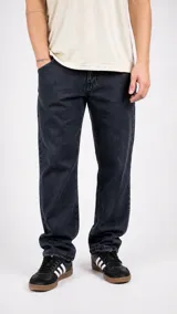 Pantalón de jean de corte recto y tiro medio, en color negro lavado. Presenta cierre frontal con botón y bolsillos laterales y traseros.