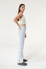 Jean celeste de tiro medio/alto, silueta levemente acampanada desde la rodilla, con tajo en el bajo y bordado floral en la pretina.