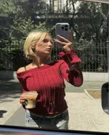 Sweater de punto trenzado color bordó, con escote estilo bote que deja los hombros al descubierto y mangas largas ligeramente acampanadas.