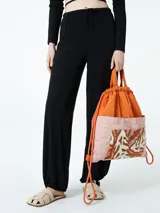 Pantalón negro de corte amplio con cintura elástica y cordón ajustable.