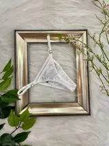 Microtanga de algodón color blanco, con diseño regulable mediante herrajes metálicos en los laterales y la cintura.