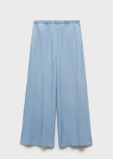 Pantalon palazzo de tiro medio confeccionado en tejido mezcla de algodón y lyocell. Presenta cintura con elástico, diseño largo y dos bolsillos laterales.
