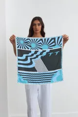 Pañuelo cuadrado de seda con estampa geométrica inspirada en detalles arquitectónicos, en tonos azul, celeste, blanco y negro.