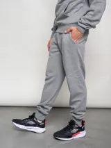 Pantalón de jogging gris melange de felpa con puños ajustados y logo de la marca estampado en la pierna.