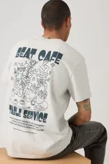 Remera gris melange de corte relaxed fit, con cuello redondo, mangas cortas y estampa pequeña en el pecho con motivo de taza de café y la inscripción "Beat Cafe".
