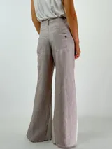 Pantalón de lino color marrón con paneles laterales en color crema y corte acampanado.