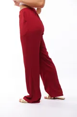 Pantalón fluido color borgoña, de tejido texturizado, con elástico en la cintura y bolsillos laterales.