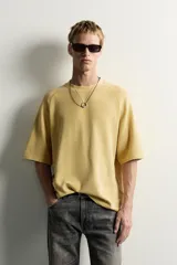 Camiseta relaxed fit de color verde militar, con cuello redondo y mangas ranglán cortas.