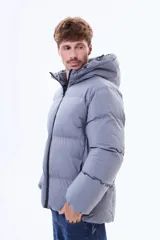Campera puffer negra con capucha, cierre frontal y puños elásticos. Diseño acolchado con relleno térmico y exterior de nylon resistente.